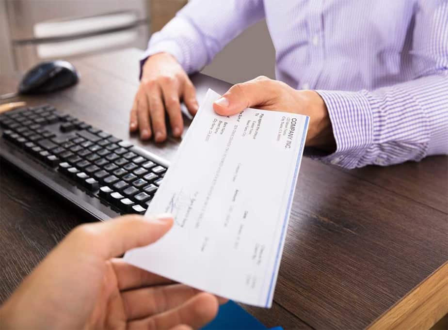 Image of someone being handed a check for payroll administration