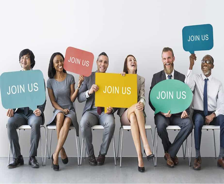 Group holding signs that say "join us" for recruiting & staffing agency